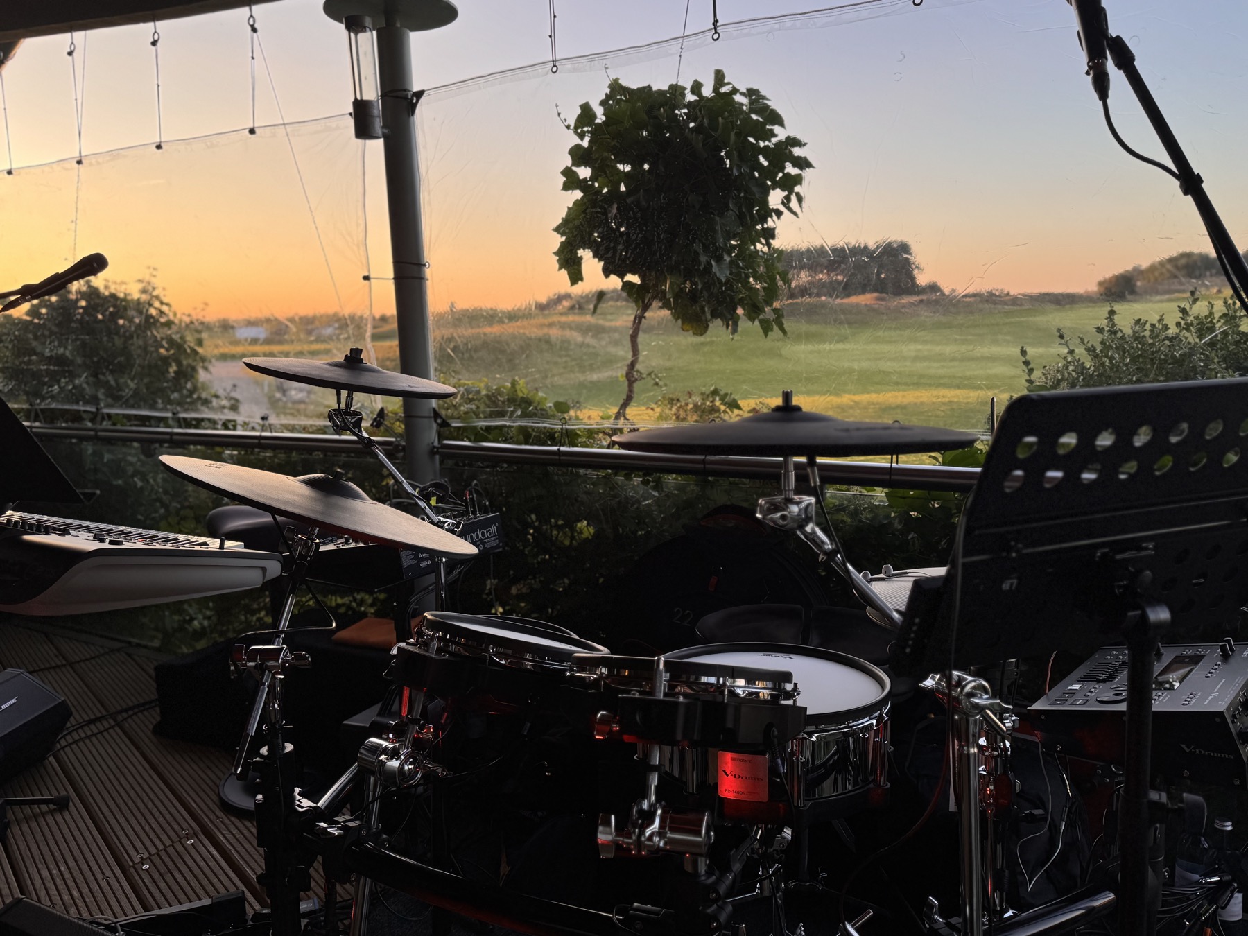 Digitales Schlagzeug und Keyboard mit Blick auf den Golfplatz im Abendlicht